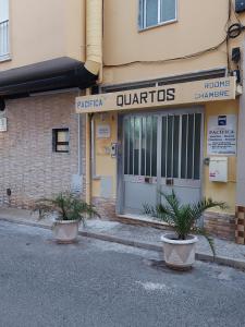 a building with two potted plants in front of it at Guest House Pacifica in Quarteira