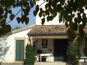 a white building with green shutters on it at I Duchi Pellegrini in Santa Maria Nuova +10 photos