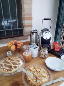 een tafel met taarten en een koffiezetapparaat en een taart bij I Duchi Pellegrini in Santa Maria Nuova