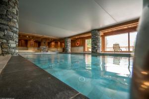 a large swimming pool in a building with at Apartment A 01 in St Martin de Belleville in Saint-Martin-de-Belleville