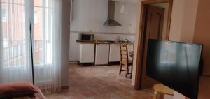ein Wohnzimmer mit einem TV und einer Küche in der Unterkunft San Roque 18 in Santo Domingo de la Calzada