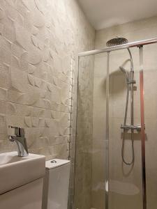 
a bathroom with a shower, sink, and toilet at Guest House D'Avenida in Vila Praia de Âncora
