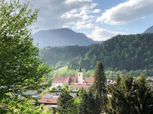 miasto w górach z kościołem i drzewami w obiekcie Grimming Appartement Schladming w mieście Sonnberg