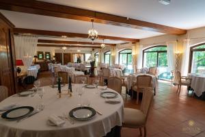 uma sala de jantar com mesas e cadeiras brancas em Moulin du Val de Seugne em Mosnac