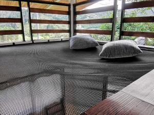 two pillows on a screened in porch with a table at Cabaña Hamacas in Cartago