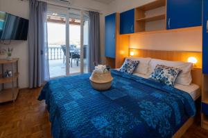 a bedroom with a bed with a blue comforter at Apartmani "MARKO" Dugovača in Drage