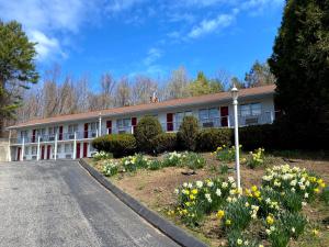 a building with a lot of flowers in front of it at Economy Lodge 682 Main St Sturbridge in Sturbridge