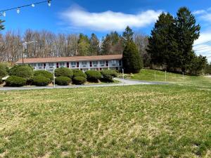 ein Gebäude mit einem Grasfeld davor in der Unterkunft Economy Lodge 682 Main St Sturbridge in Sturbridge