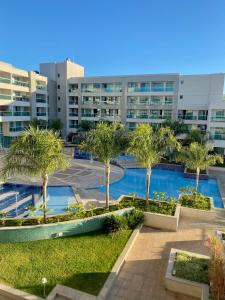 a courtyard with palm trees in front of a building at Brisas do Lago - Apartamento 8 in Brasilia