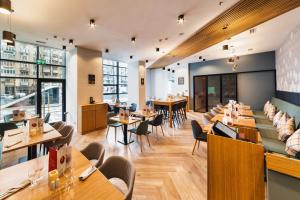 a restaurant with wooden tables and chairs at Holiday Inn Bucharest - Times by IHG in Bucharest