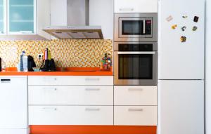 a kitchen with white cabinets and a microwave at Piso de diseño junto al centro de Murcia con parking in Murcia