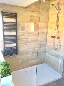 een badkamer met een douche en houten wanden bij Bendalong Noordwijk in Noordwijk
