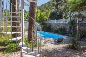 a swimming pool in a yard with a spiral staircase at Racó del Molló in Gandía