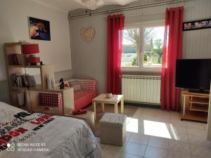 a bedroom with a bed and a window with red curtains at La Bedosse in Alès