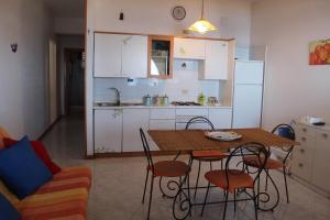 a kitchen with a table and chairs and a kitchen with white cabinets at CasaLella in Letojanni