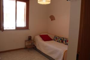 a small bedroom with a bed and a window at CasaLella in Letojanni