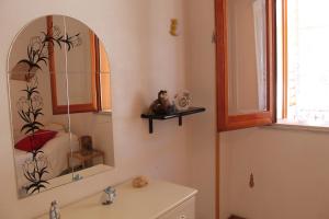 a bathroom with a sink and a mirror on the wall at CasaLella in Letojanni