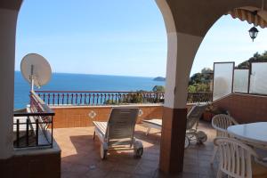 a balcony with chairs and a table and the ocean at CasaLella in Letojanni