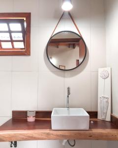 a bathroom with a white sink and a mirror at Capim Canoa in Alto Paraíso de Goiás