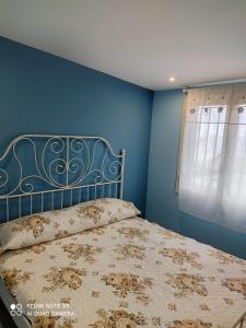 レトイアンニにあるCasa relax Letojanni- taorminaのベッドルーム1室(青い壁のベッド1台、窓付)