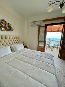 a bedroom with a large bed with a view of the ocean at Sofotel in Koroni