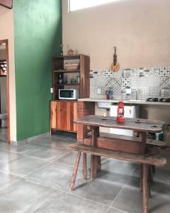 a kitchen with a wooden table and a microwave at Capim Canoa in Alto Paraíso de Goiás +36 photos