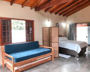 a bedroom with a bed and a couch in a room at Capim Canoa in Alto Paraíso de Goiás