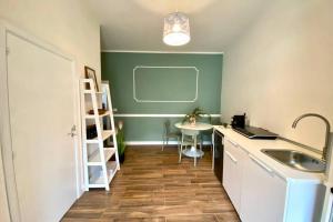 cocina con fregadero y mesa en una habitación en La Casetta di Rosie, alla Torre Guevara, en Potenza