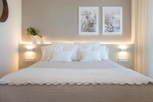 una camera da letto con un letto bianco con cuscini bianchi di Hotel Rural Tierras del Cid a Quintanadueñas