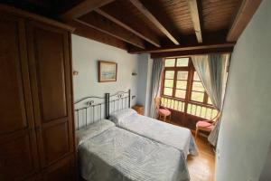a bedroom with a bed and a window at Casa Triana, lugar idóneo para 4 o 6 huéspedes. in Infiesto