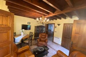 a living room with a chandelier and a table and chairs at Casa Triana, lugar idóneo para 4 o 6 huéspedes. in Infiesto