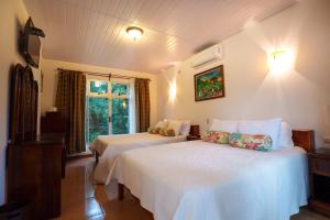 a hotel room with two beds and a window at Hotel Eco Arenal in Fortuna
