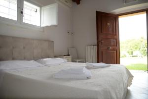 a bedroom with a white bed with towels on it at Hotel Ristorante Termitito in Scanzano