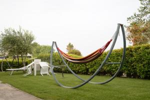 a hammock in a garden with a table and chairs at Hotel Ristorante Termitito in Scanzano