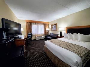 a hotel room with a large bed and a flat screen tv at Ramkota Hotel Pierre in Pierre