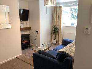 a living room with a couch and a fire place at Pendower Apartment in Wadebridge