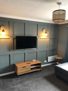 基斯高地Sinclair Bay Apartments的客厅墙上有一台平板电视