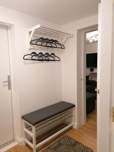 a walk in closet with a bench and shoes at Chota Gher Apartment in Widnes