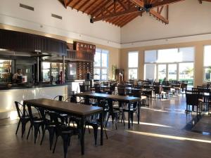 un restaurant avec des tables et des chaises ainsi qu'un bar dans l'établissement Howard Johnson Resort & Convention Center Ezeiza, à Ezeiza