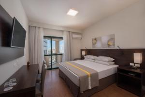 um quarto de hotel com uma cama e uma televisão em Costa Mar Recife Hotel by Atlantica no Recife