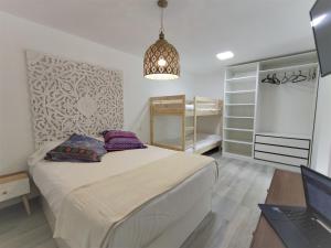 1 dormitorio con cama y escritorio con ordenador portátil en Estudios Playa de Covachos, en Soto de la Marina