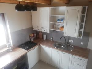 a kitchen with white cabinets and a sink at Domek w Cisnej pod Honem 2 in Cisna