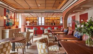 a restaurant with wooden tables and chairs and a bar at Hotel de Silhouette in Biarritz