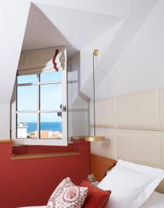 a bed sitting in the middle of a room next to a window at Hotel de Silhouette in Biarritz