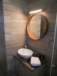 W łazience znajduje się umywalka i lustro. w obiekcie Lux Sea Apartment - Porto Rafti w mieście Porto Rafti