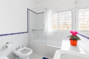 a white bathroom with a toilet and a sink at LA ARMONIA in Córdoba +5 photos