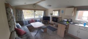 a small living room with a couch and a kitchen at The Hackle Hot Tub Retreat in Felton