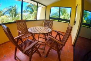uma varanda com uma mesa, cadeiras e janelas em Magnifica y comoda Villa 85 a 100 mts del Mar em Celestún