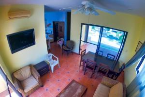 uma sala de estar com um sofá, uma mesa e cadeiras em Magnifica y comoda Villa 85 a 100 mts del Mar em Celestún