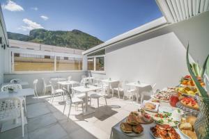 ein Zimmer mit Tischen und Stühlen und Essen auf einem Tisch in der Unterkunft Oasi del Golfo Suites B&B in Castellammare del Golfo
